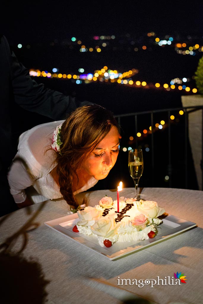 La sposa spegne una candelina per il suo compleanno al termine del ricevimento di nozze a Villa Pocci