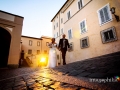 Gli sposi entrano a Castel Gandolfo con la luce del tramonto che filtra dalla porta del borgo