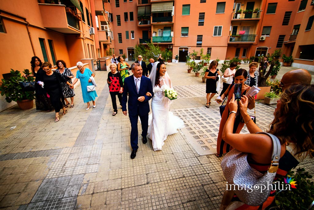 La sposa, accompagnata dal padre, esce di casa passando per il mega cortile
