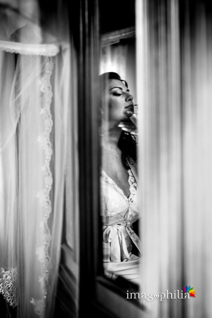 La sposa riflessa in uno specchio durante la preparazione