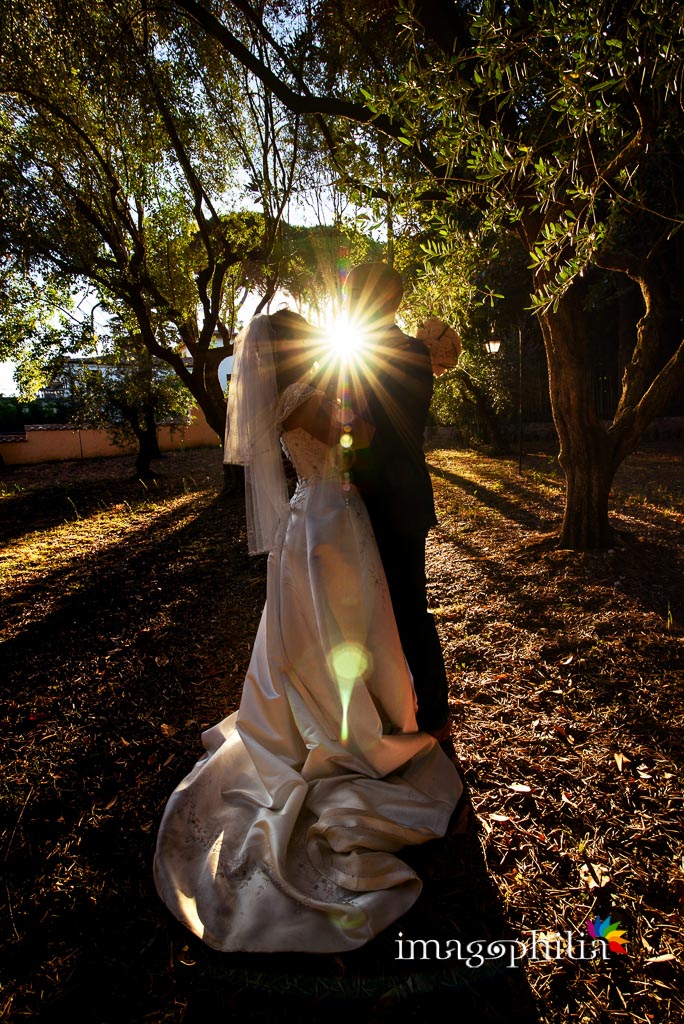 Il sposi ritratti in controluce al tramonto nel boschetto della Villa dei Volsci a Velletri