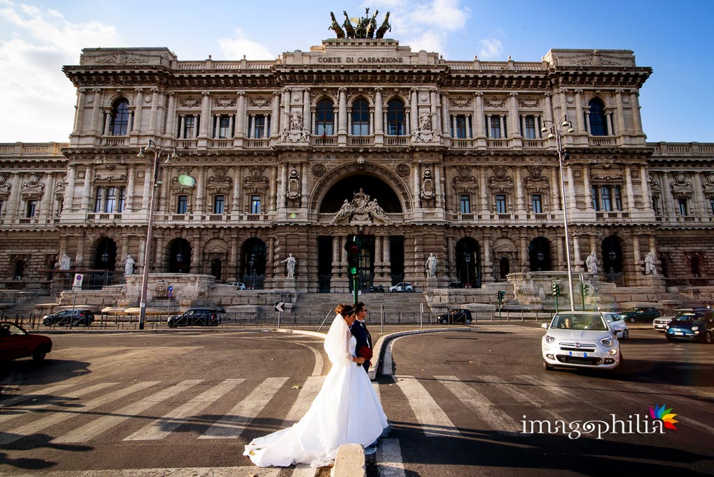 Gli sposi ritratti davanti al Palazzo di Giustizia a Roma