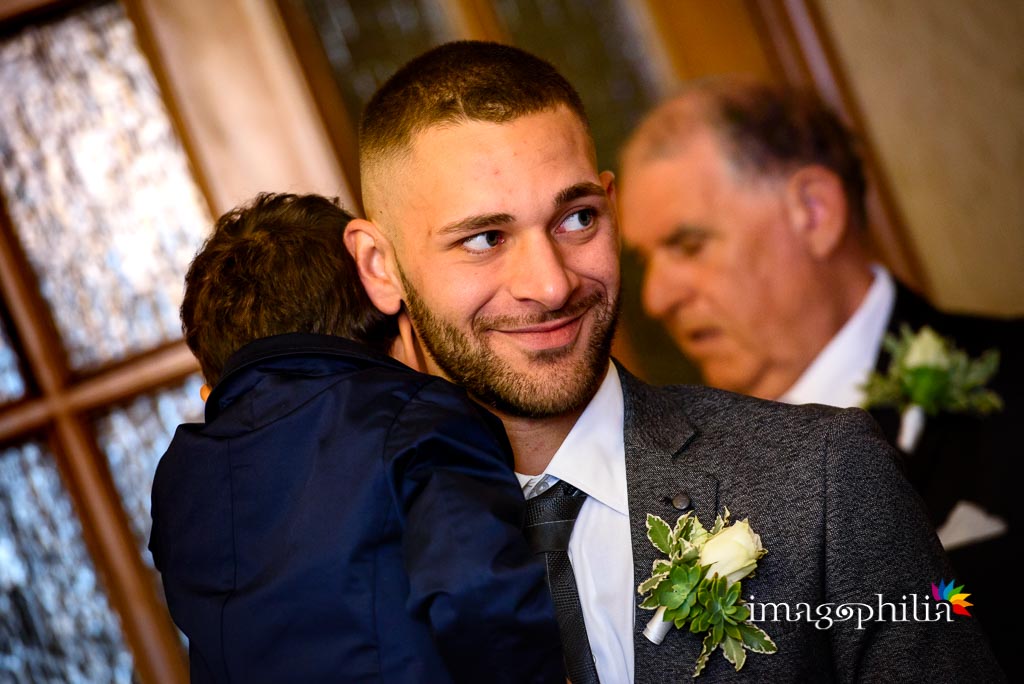 Un figlio della sposa ne tiene in braccio un altro