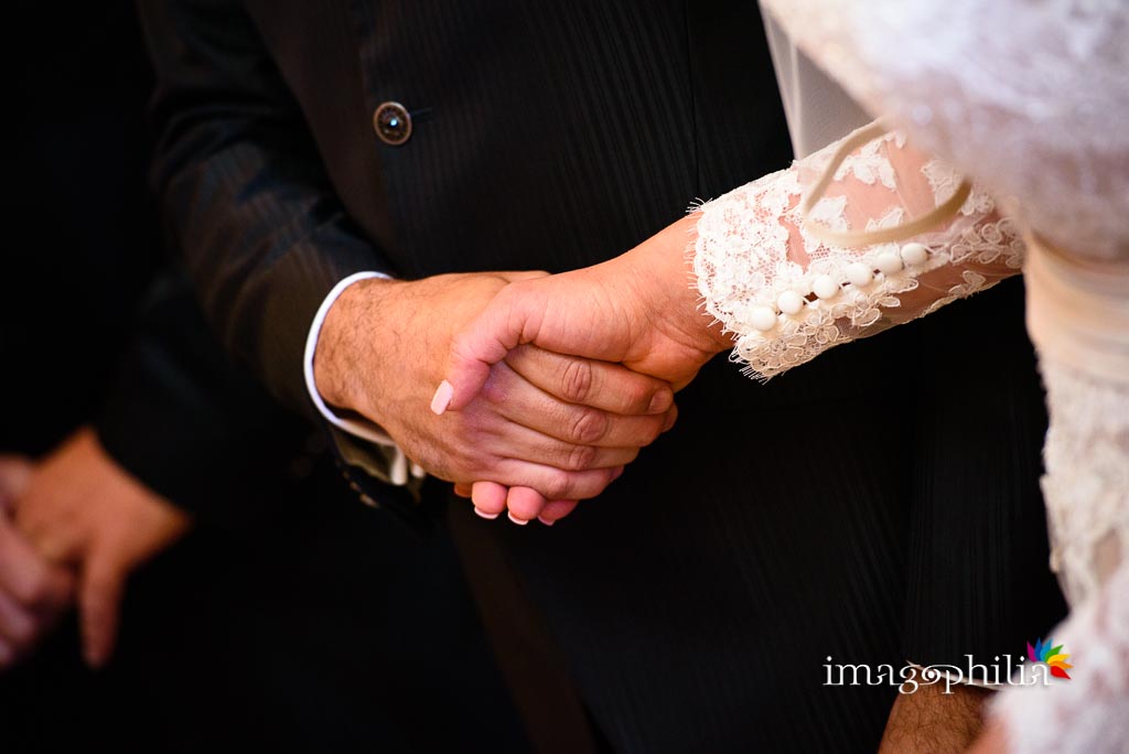 Gli sposi si stringono le mani durante il matrimonio nella Chiesa Aeroportuale di Guidonia Santa Maria di Loreto