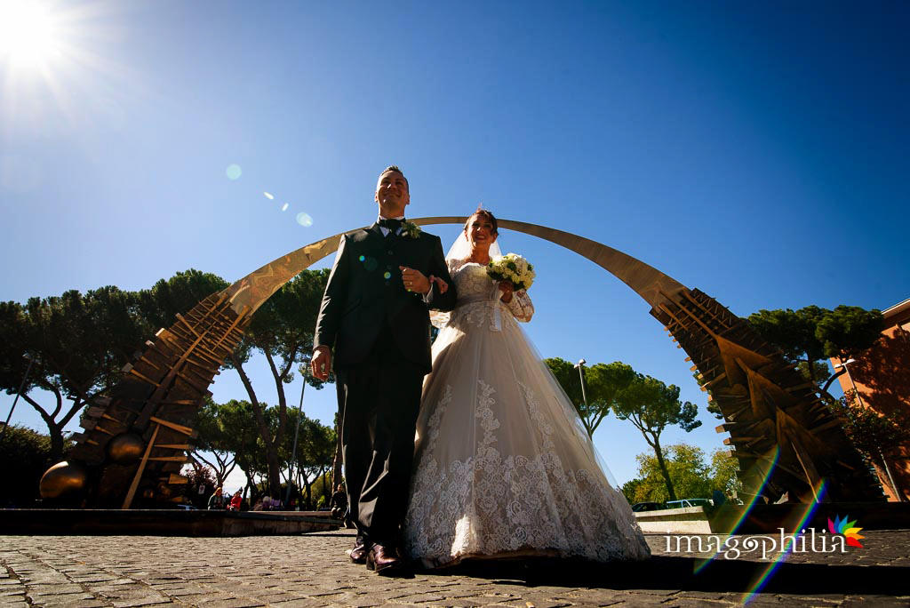 Gli sposi "trionfano" sotto un arco a Tivoli, subito prima della sessione esterna a Villa d'Este