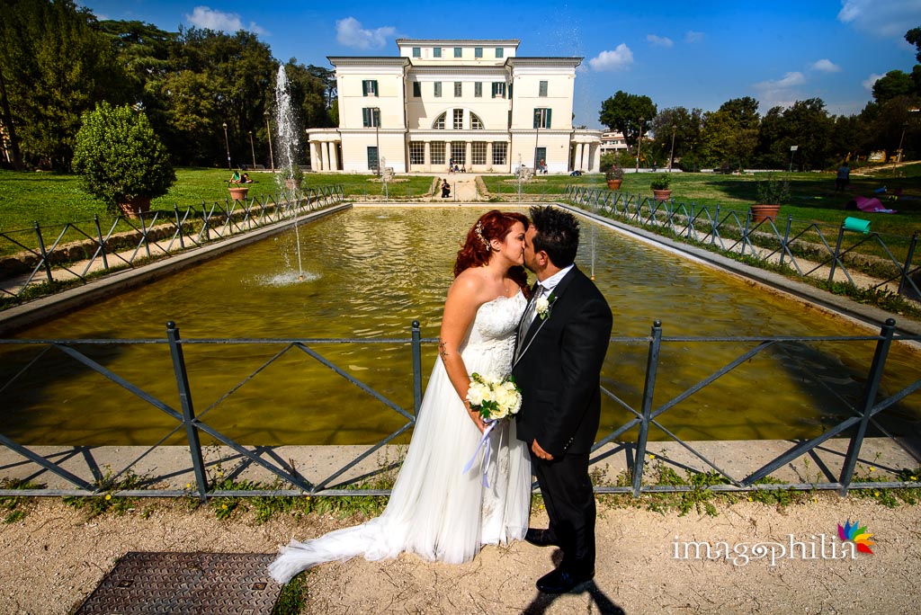 Bacio tra gli sposi durante la sessione fotografica in esterno a Villa Torlonia, Roma / 2
